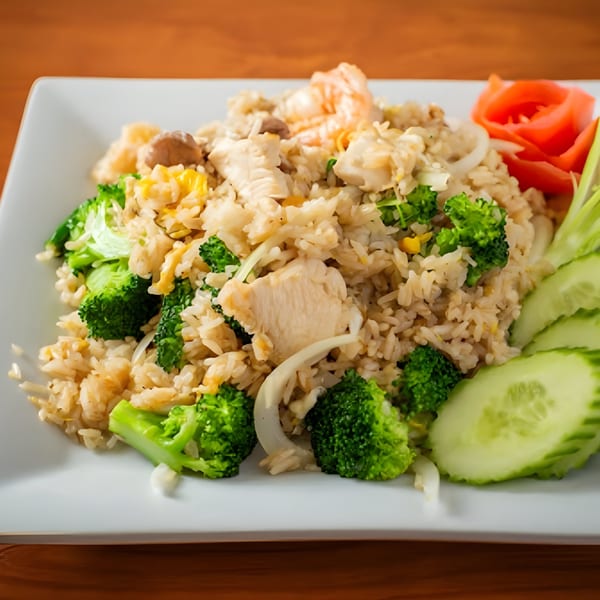 SaiMai Thai Restaurant's fried rice with chicken, shrimp, broccoli, and cucumber slices on a white plate.