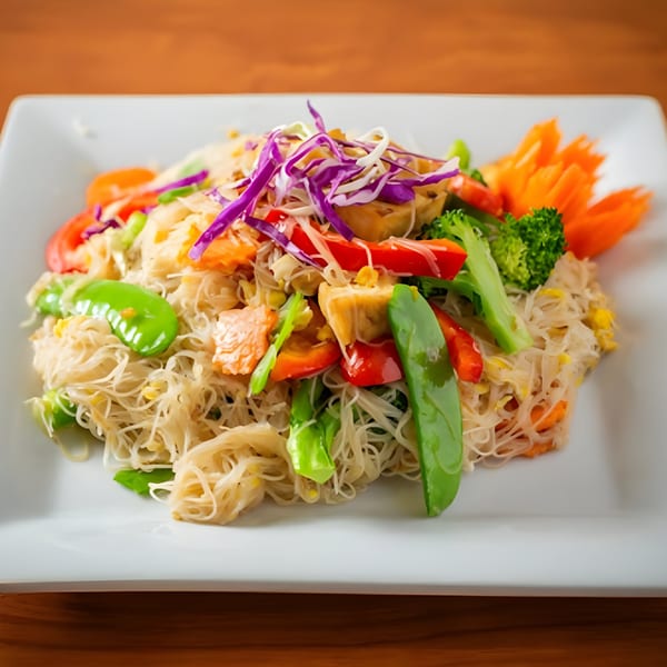 SaiMai Thai Restaurant's vermicelli noodles with colorful vegetables, tofu, and shredded cabbage on a white plate.